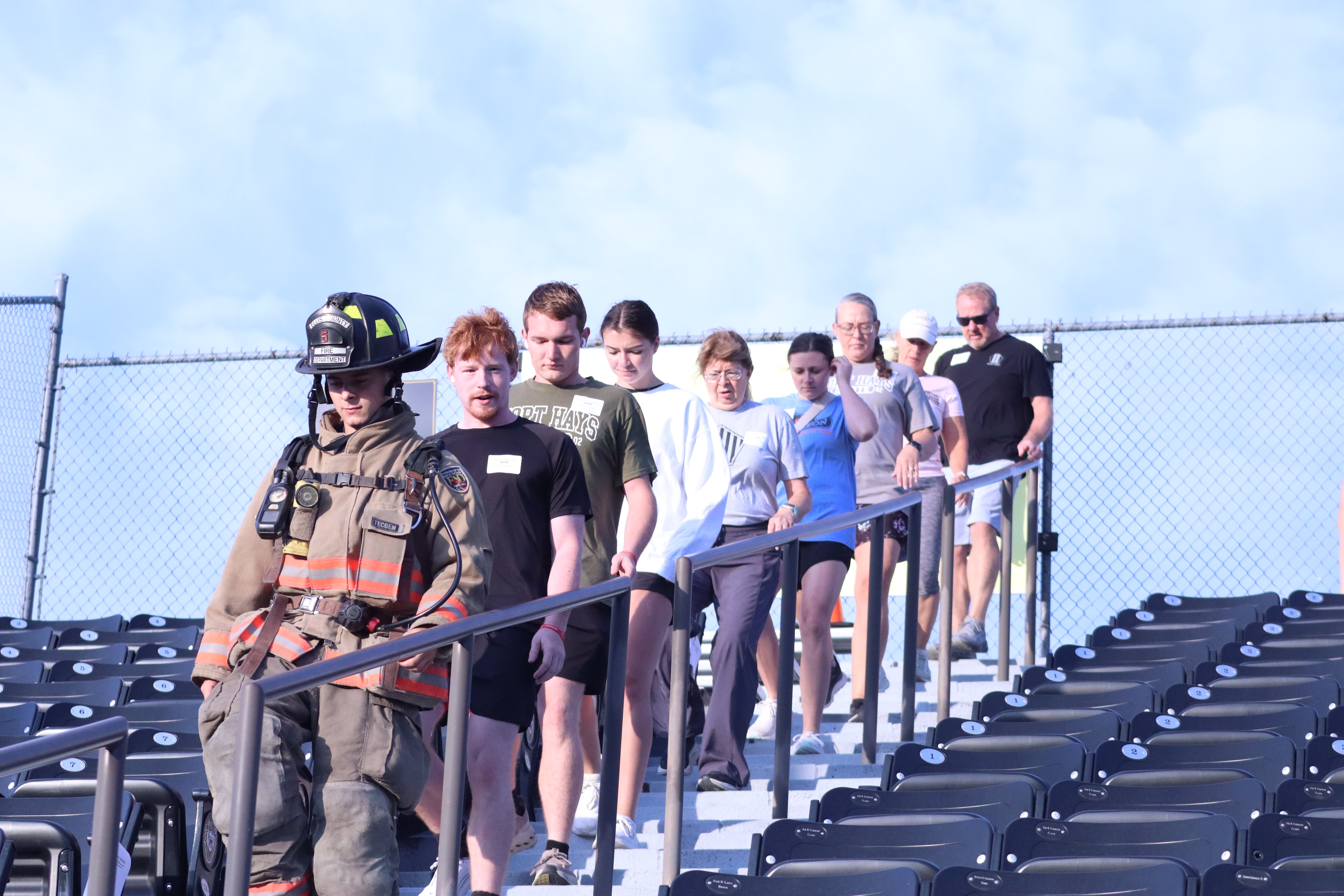 Hays Firefighter Kamden Keller leads a group down the stairs during the Stair Climb at Lewis Field.&nbsp;