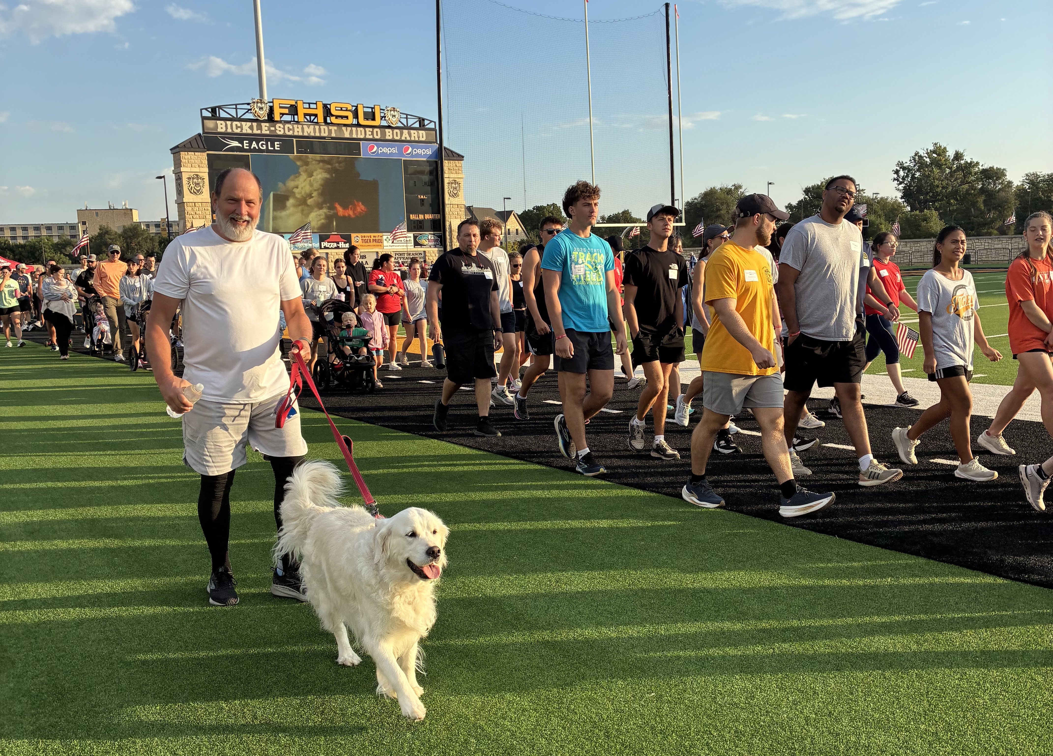 Dan Jachetta walks around Lewis Field to remember those who lost their lives on 9/11 with his dog Bailey.&nbsp;