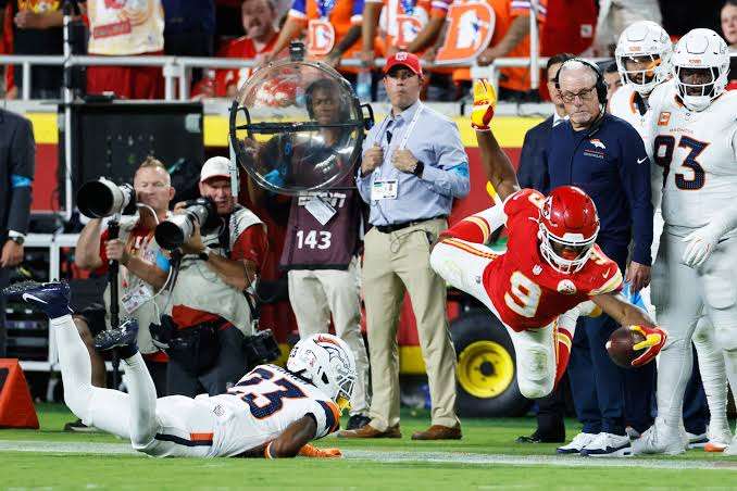 Kansas City Chiefs running back Kenneth Walker III (9) catches a pass and dives for a first down against Denver Broncos cornerback Jahdae Barron (23) during the first half of an NFL football game Monday, Sept. 14, 2026, in Kansas City, Mo. (AP Photo/Colin E. Braley)