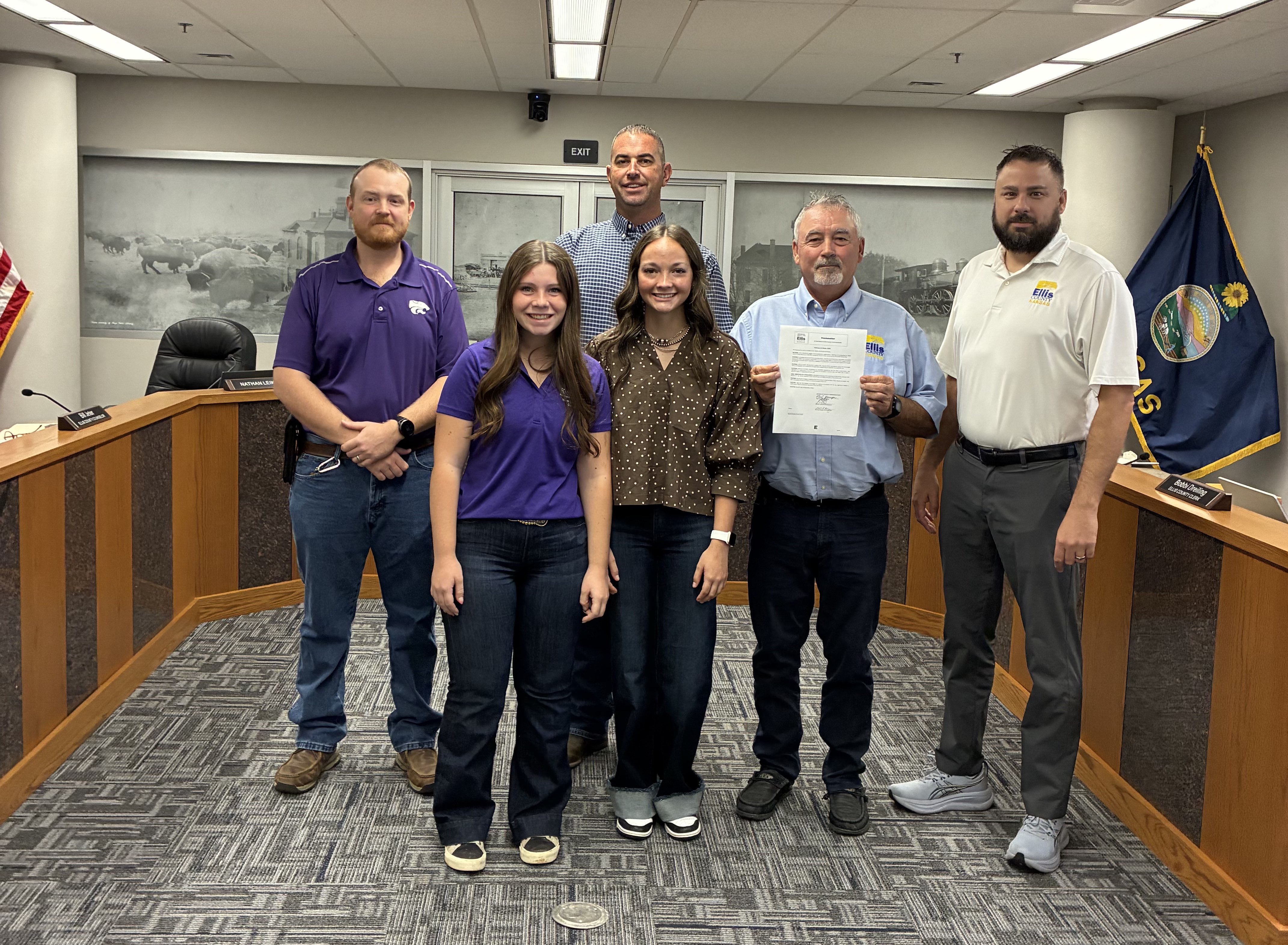 Ellis County Commissioners pose with 4-H Youth Development Agent Ben Sims and 4-H members. From left: Ben Sims, Nathan Leiker, Neal Younger, Michael Burgess. Front row, from left: Faith Schmeidler, Brynlee Walter. Photo by Alin Hett/Hays Post&nbsp;