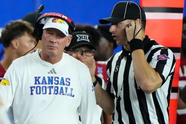 Kansas head coach Lance Leipold talks with an official during the second half of an NCAA college football game against Missouri, Friday, Sept. 11, 2026, in Lawrence, Kan. (AP Photo/Charlie Riedel)