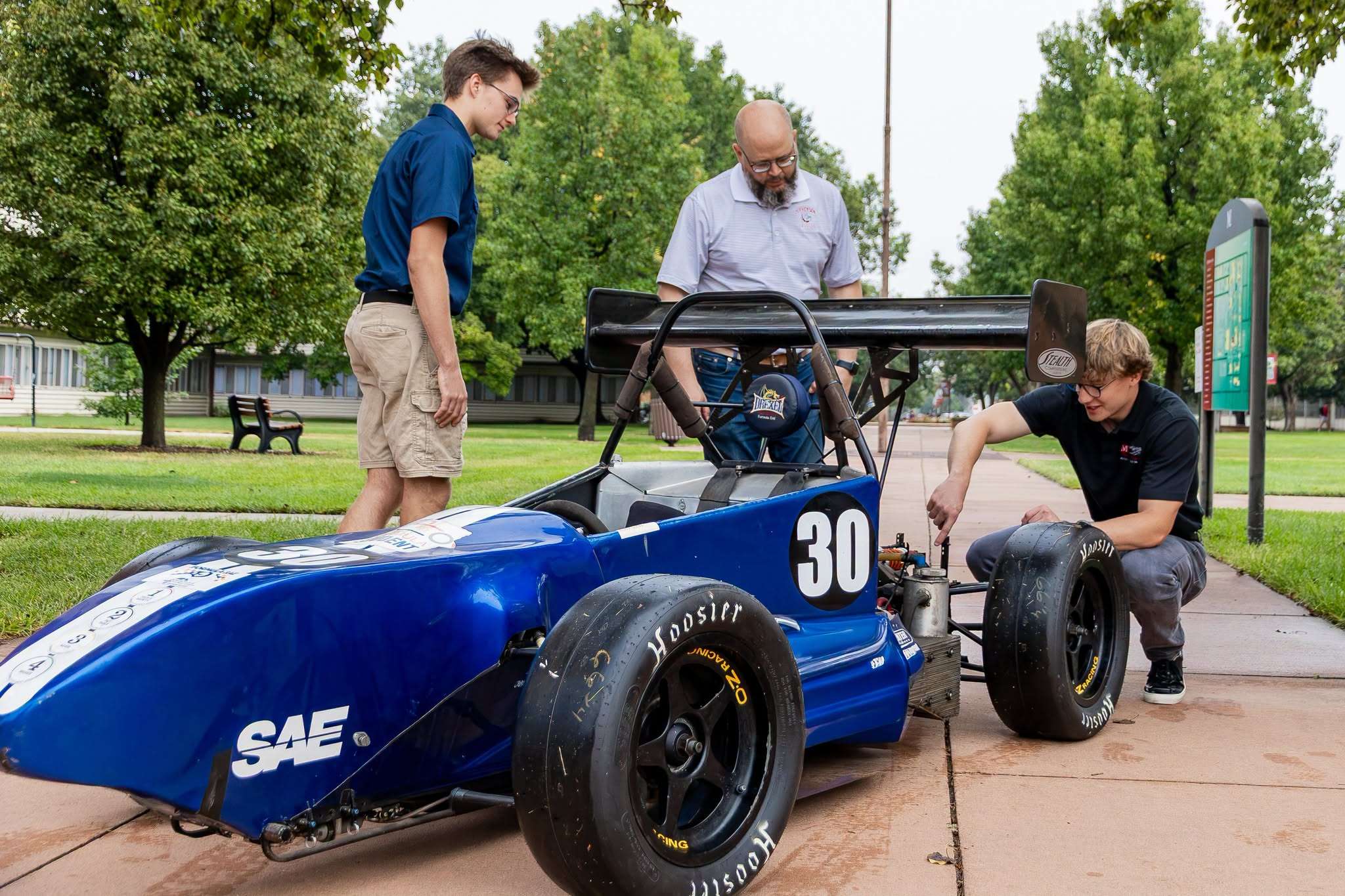 Dr. Michael Stichter and McPherson College students look over a Formula SAE vehicle as the college prepares to add a motorsport team. (Photo courtesy McPherson College)