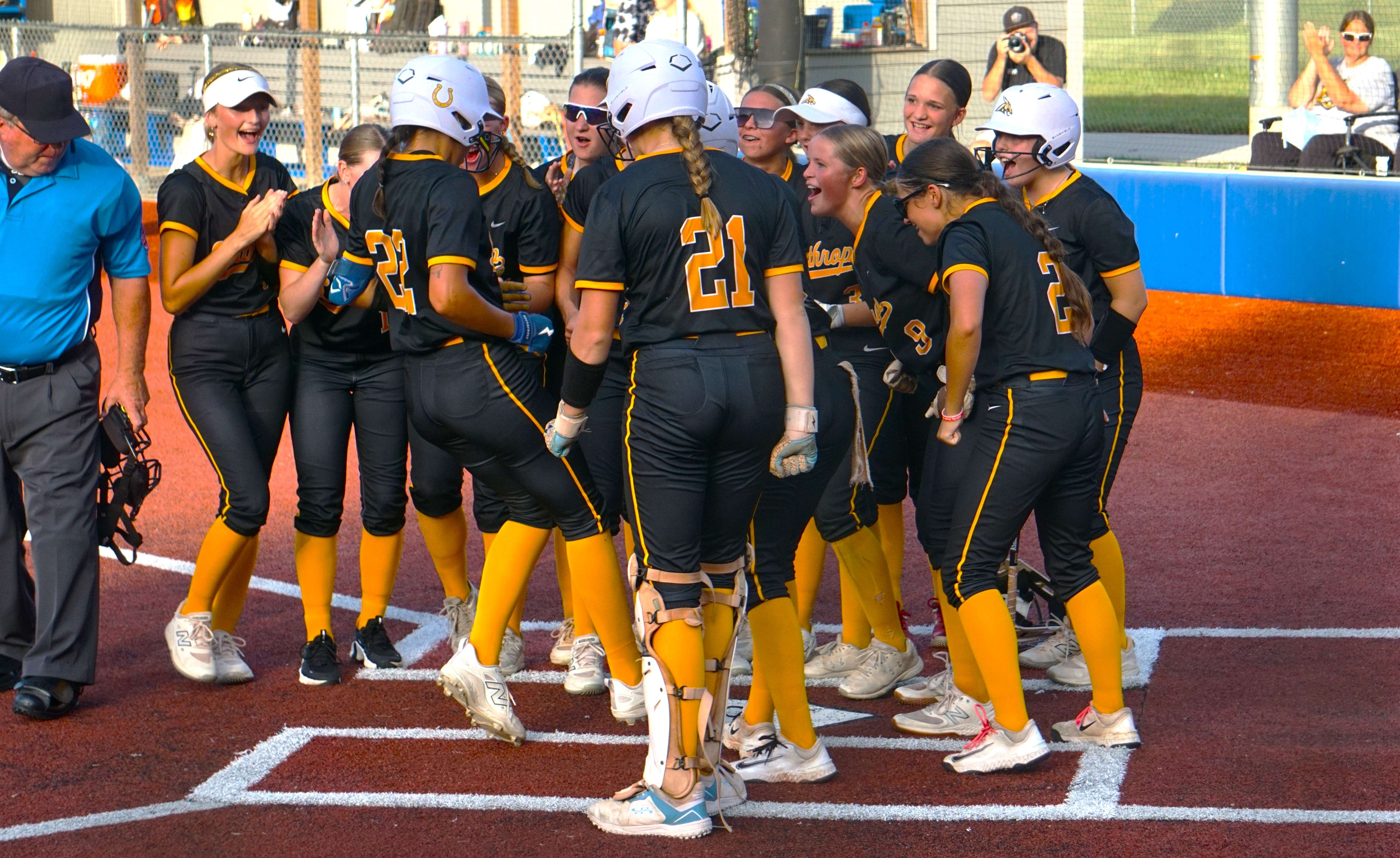 The Lathrop softball team celebrates after Jacie Kassanavoid (22) hits a two run home run in the first inning/Photo by Matt Pike