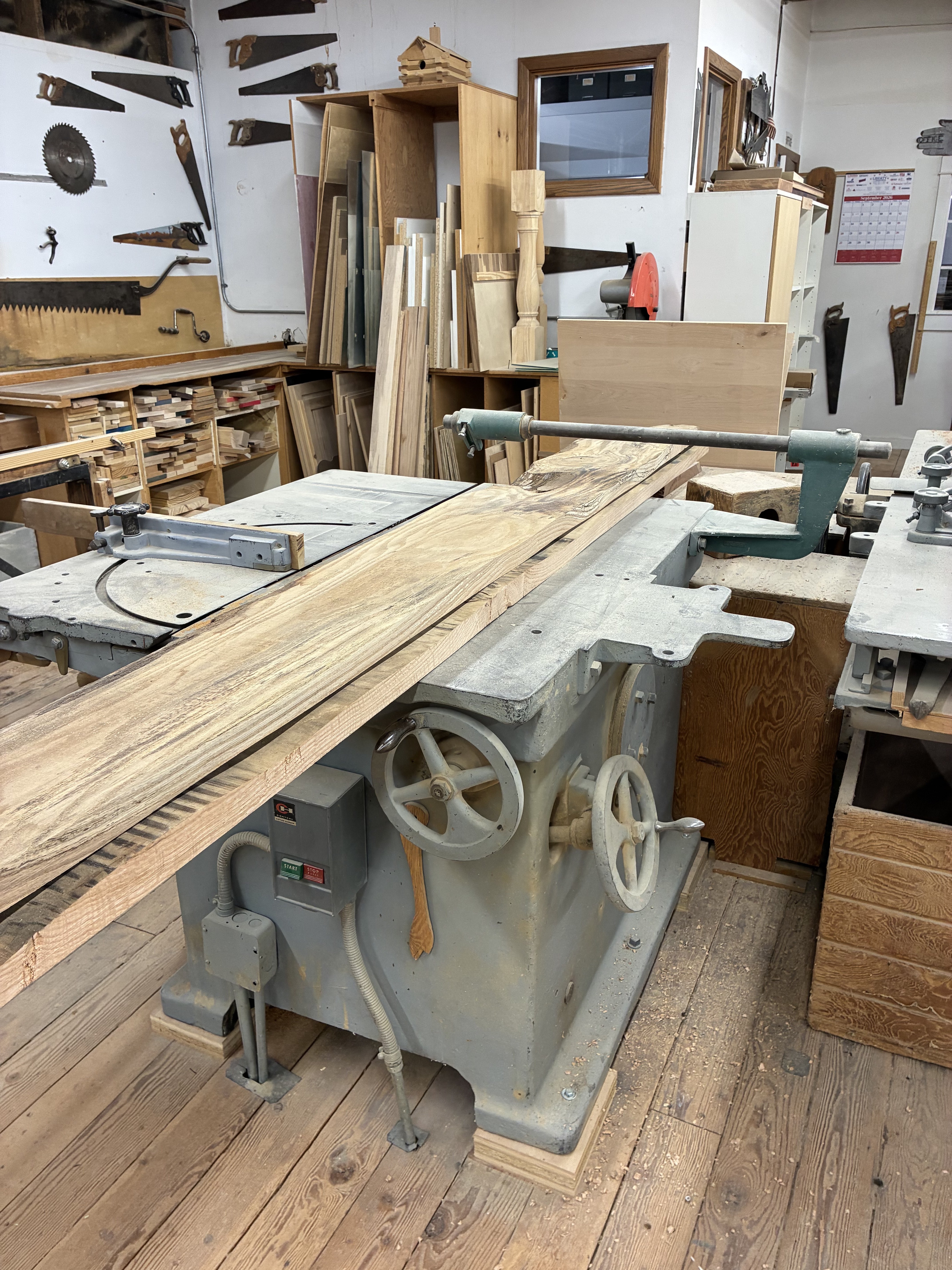 Lumber rests atop one of the woodworking machines inside the Hays Planing Mill workshop.<br>