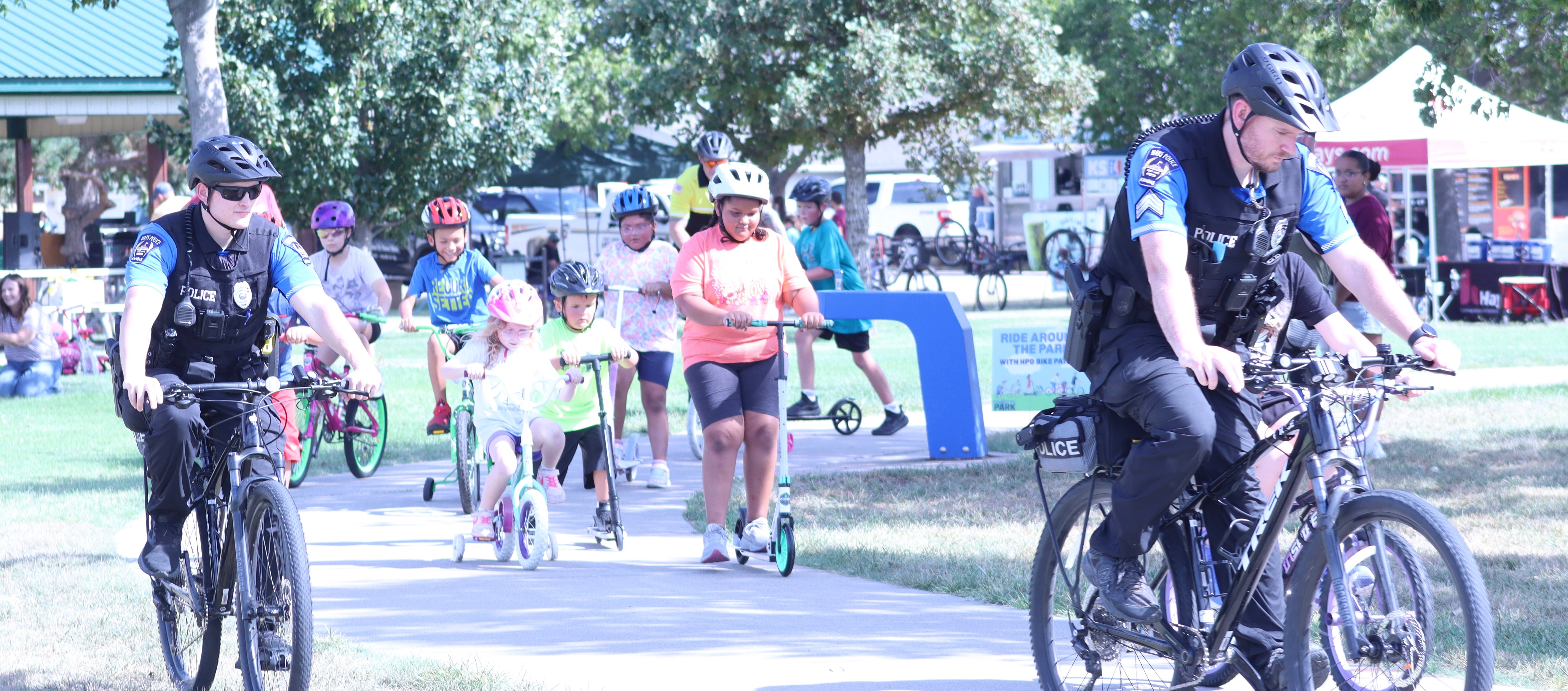 Hays Police Department leads kids through Auble Bickle park for Pedal Patrol in the Park 2026.&nbsp;