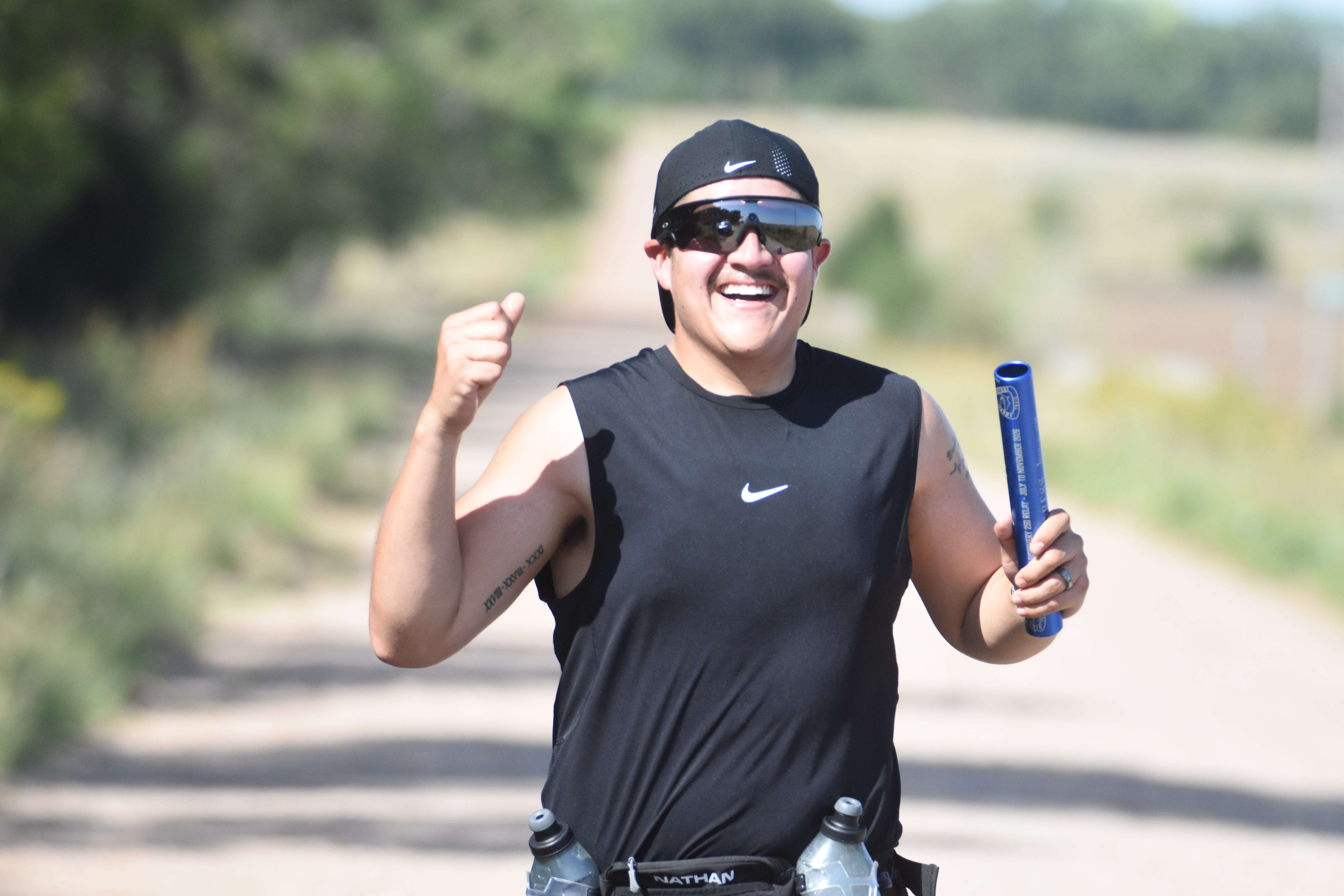Alcala celebrates the end of his leg on a hot September morning. The local portion of the relay included a trip down Main Street in Great Bend, then several miles of rural running on NE 10 Avenue to NE 60 Road into Cheyenne Bottoms. (photo by Mike Courson)