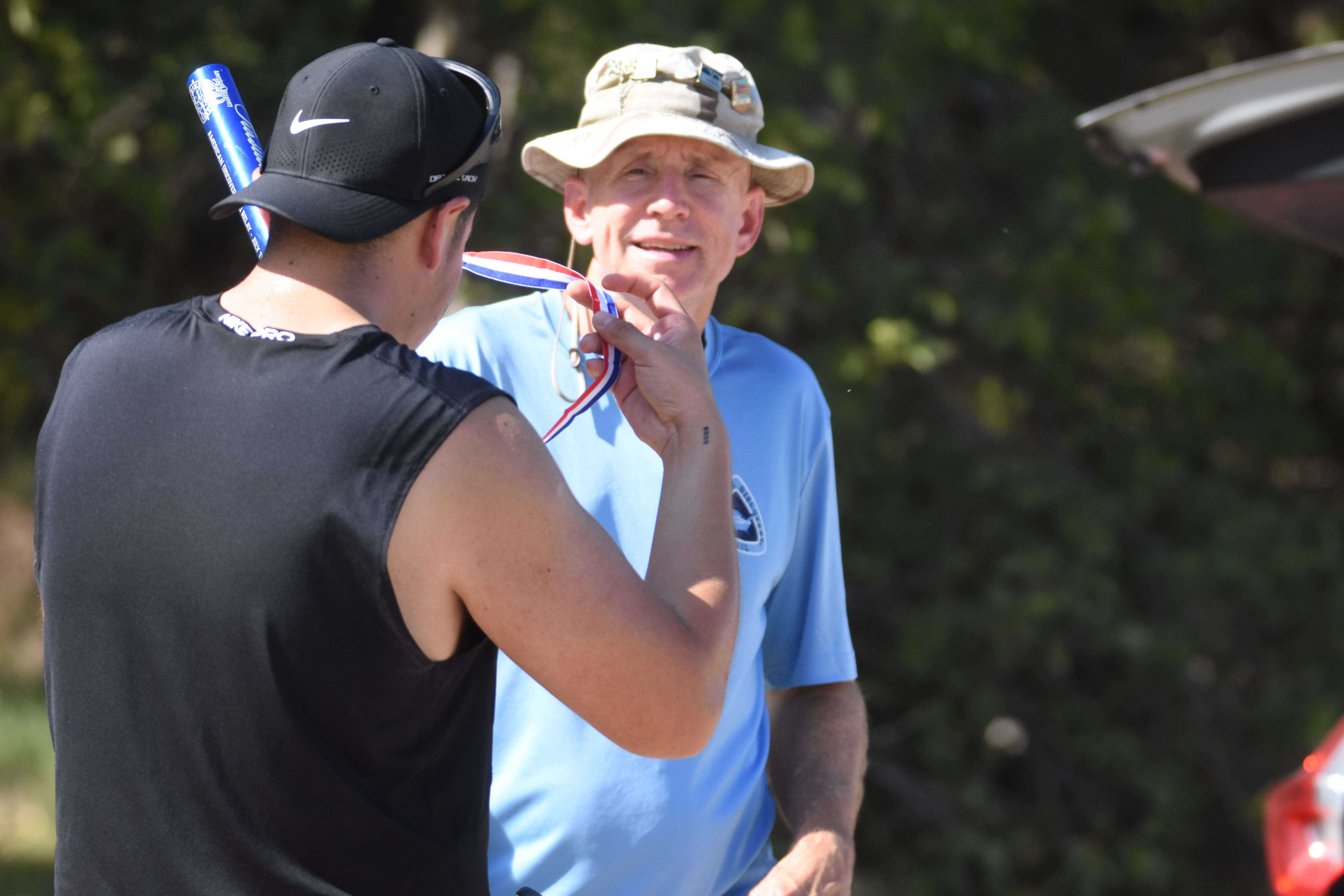Alcala gets his finishers medallion from Mike Leland, America 250 relay coordinator. (photo by Mike Courson)