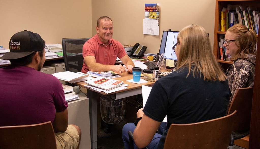 Dr. Tom Smith, center, helps students design their class schedules during New Student Registration and Orientation June 21, 2019, in Old Admin. (Photo by Tena L. Cook/Chadron State College)
