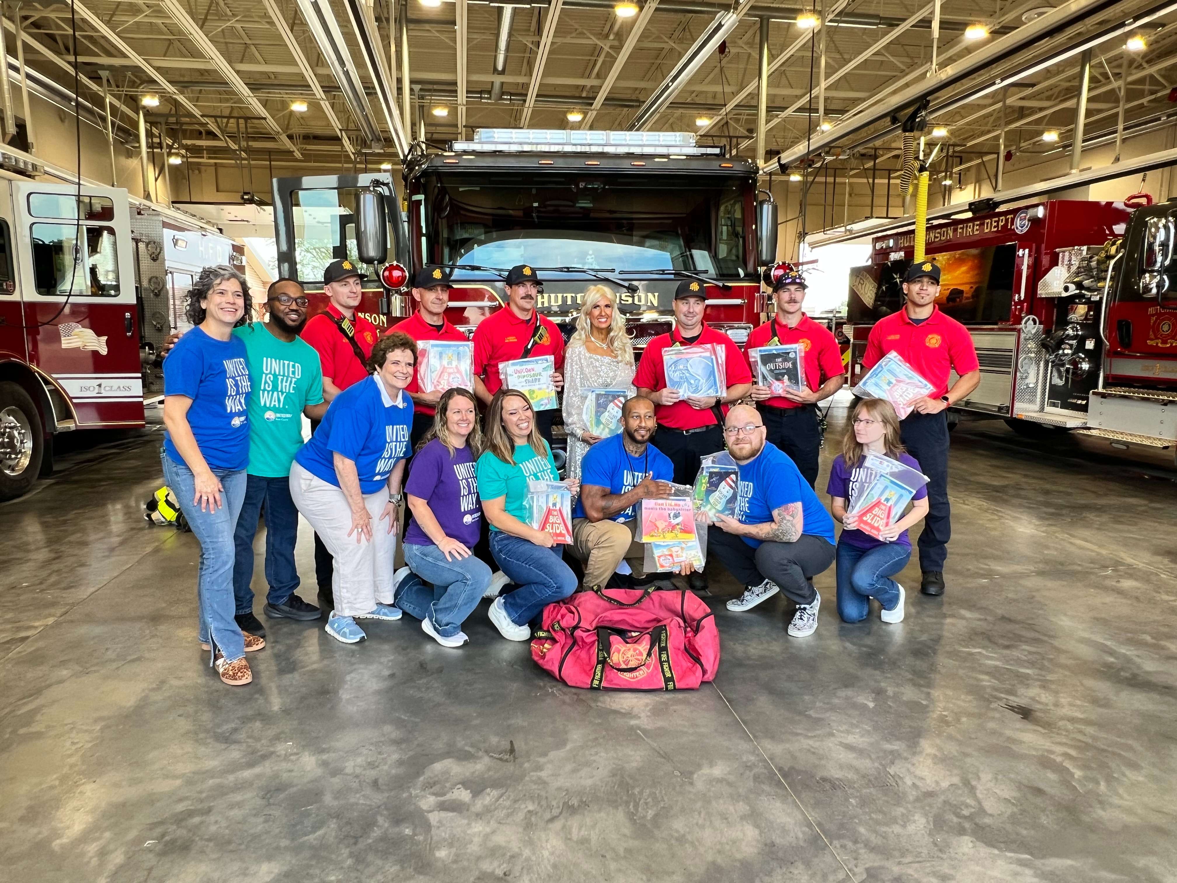 Members of United Way of Reno County and the Hutchinson Fire Department pose with books from the Dolly Parton Imagination Library on Friday, Sept. 25, 2026, at Fire Station No. 1. The books will be distributed by firefighters to children during emergency calls and community events as part of a new partnership between the two organizations. (Hutch Post Photo/Sean Boston)