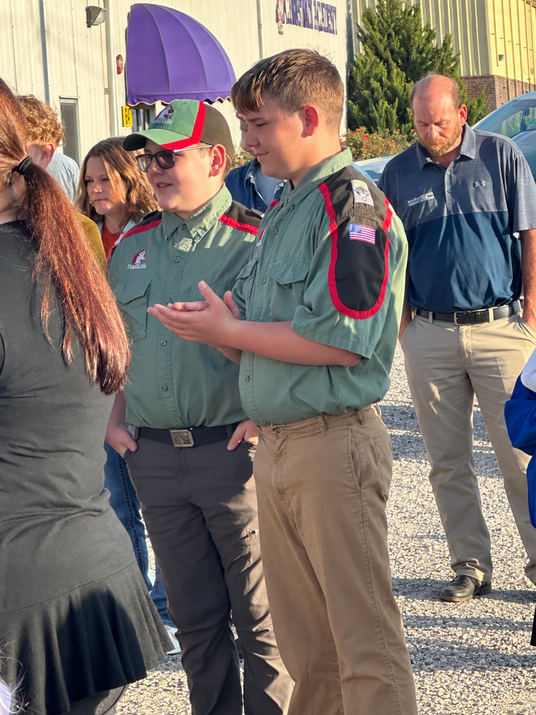 CKCA sixth-graders Lawson Seal, left, and Cole Nokes participate in the school’s See You at the Pole gathering on Sept. 23 while wearing their Trail Life USA uniforms. CKCA students involved in Trail Life were invited to wear their uniforms for the event as a way of showing respect for the American flag.
