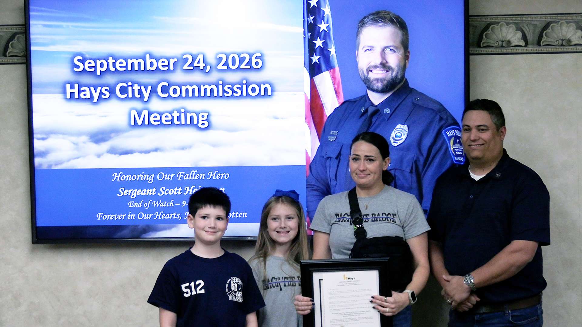 Hays Mayor Mason Ruder presented a proclamation honoring fallen Hays Police officer Sgt. Scott Heimann to his children and wife at Thursday's city commission meeting. Photo by Becky Kiser/Hays Post