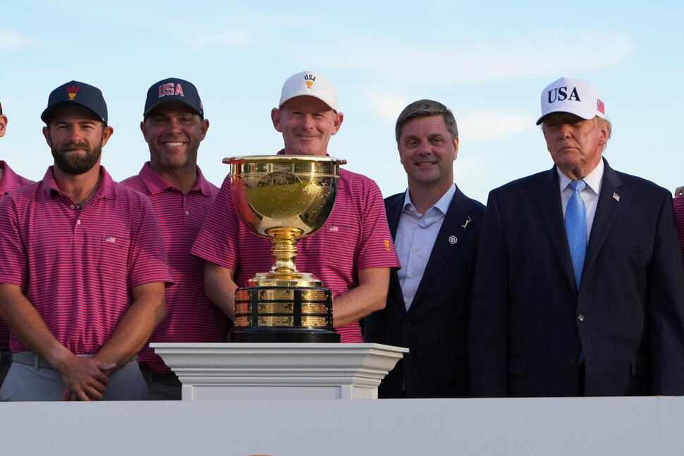 President Donald Trump, right, poses with members of the USA team after presenting them with the Presidents Cup trophy at the Presidents Cup golf tournament at Medinah Country Club, Sunday, Sept. 27, 2026, in Medinah, Ill. (AP Photo/Julia Demaree Nikhinson)