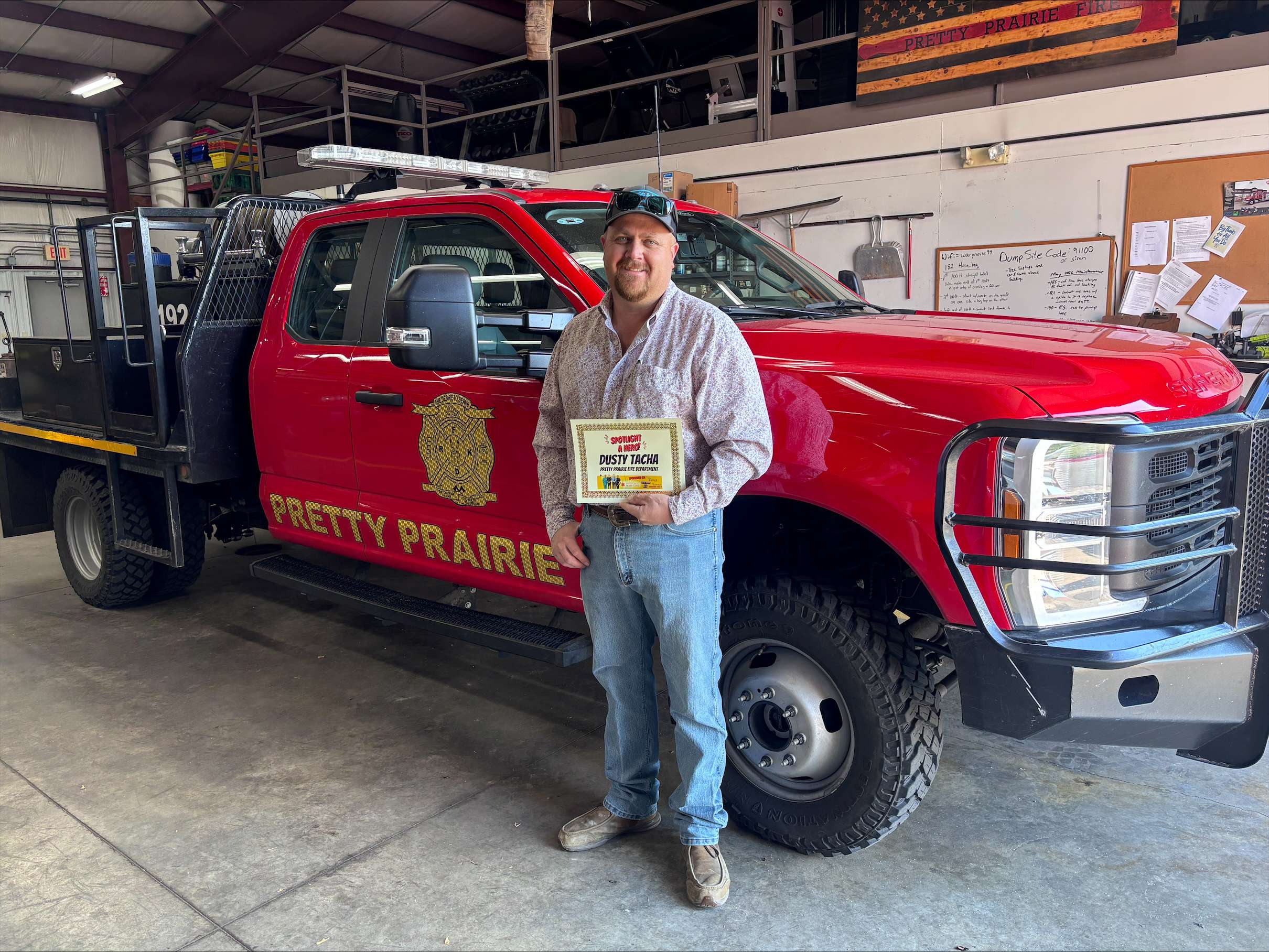 Dusty Tacha, a captain with Reno County Fire District No. 1, Station 10, poses with his September First Responder of the Month award in Pretty Prairie. (Hutch Post Photo)